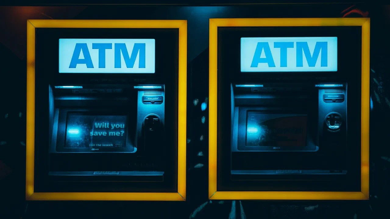 Two automated teller machines set side by side in a wall at night