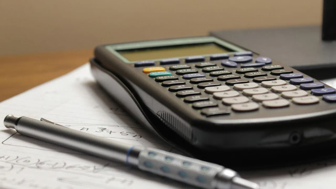 A calculator and a pen resting on a sheet of paper